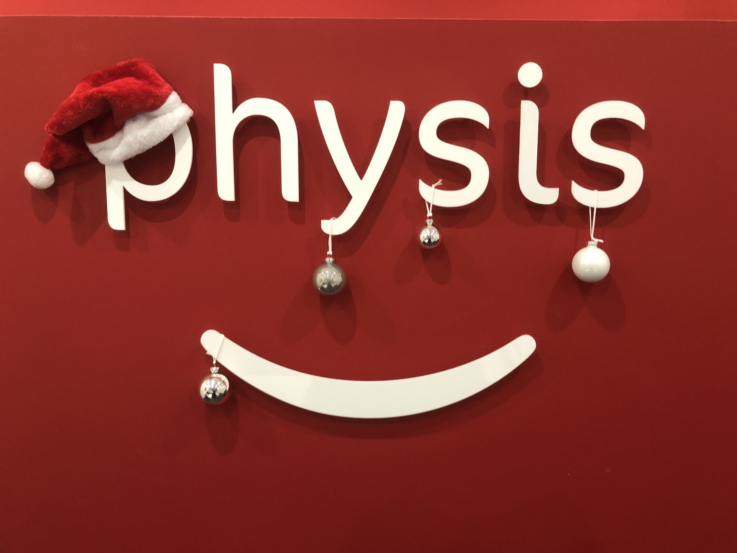 Physis Physiotherapy Logo wearing a Christmas hat and Christmas baubles